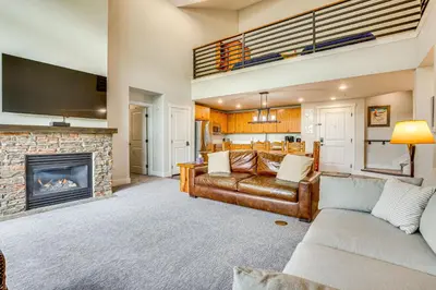 a living room with a couch and a fireplace at Ski-InandSki-Out Granby Penthouse with Mountain Views! in Granby