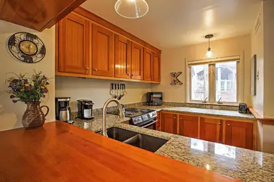 a kitchen with wooden cabinets and a sink at Hot Tub and Grilling Area Keystone Townhome! in Keystone