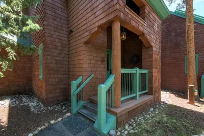 a house with a front porch with green railings at Hot Tub and Grilling Area Keystone Townhome! in Keystone