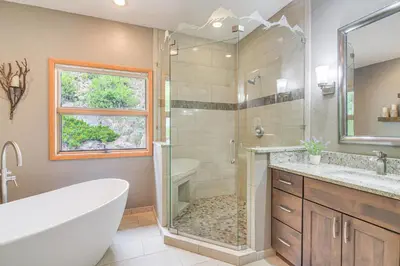 a bathroom with a shower and a tub and a sink at Stunning Mtn Views, Private Stream Evergreen Gem! in Evergreen