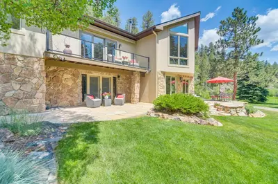 a house with a patio and a yard at Stunning Mtn Views, Private Stream Evergreen Gem! in Evergreen