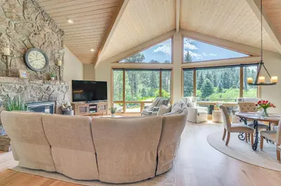 a large living room with a large stone wall at Stunning Mtn Views, Private Stream Evergreen Gem! in Evergreen