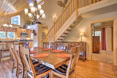 a dining room and kitchen with a wooden table and chairs at Luxury 4 BR Cabin 2 King Suites on Shuttle Route in Winter Park