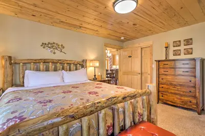 a bedroom with a bed and a dresser in a room at Luxury 4 BR Cabin 2 King Suites on Shuttle Route in Winter Park