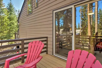 two pink chairs sitting on the front porch of a house at Luxury 4 BR Cabin 2 King Suites on Shuttle Route in Winter Park