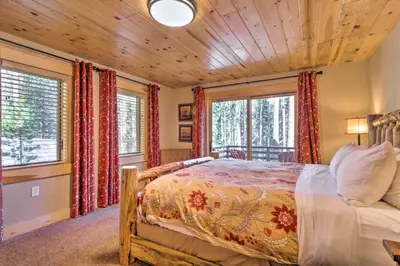 a bedroom with a bed and two windows at Luxury 4 BR Cabin 2 King Suites on Shuttle Route in Winter Park