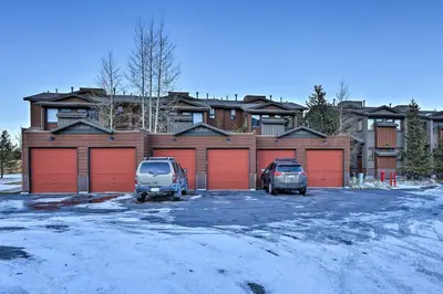 two cars parked in a parking lot in front of a house at Walk to Main Street Frisco Townhome with Decks in Frisco
