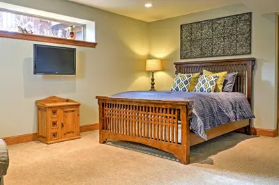 a bedroom with a crib and a flat screen tv at Fraser Townhome with Mtn Views - 6 Mi to Winter Park in Fraser