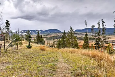 a dirt road in a field with mountains in the background at Fraser Townhome with Mtn Views - 6 Mi to Winter Park in Fraser