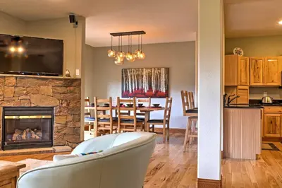 a living room and a dining room with a fireplace at Fraser Townhome with Mtn Views - 6 Mi to Winter Park in Fraser