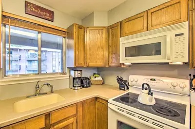 a kitchen with a white stove and a microwave at Winter Park Condo on Bus Route, 2 Blocks to Dtwn! in Winter Park