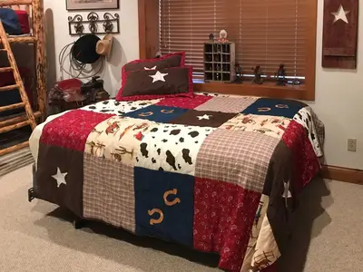 a bedroom with a bed with a quilt with animals on it at 2 Mi to Skiing Mtn-View Home with Deck in Granby! in Granby