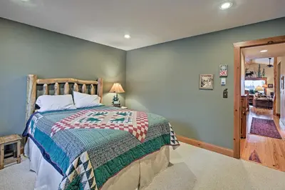 a bedroom with a bed with a wooden head board at 2 Mi to Skiing Mtn-View Home with Deck in Granby! in Granby