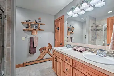 a bathroom with two sinks and a large mirror at 2 Mi to Skiing Mtn-View Home with Deck in Granby! in Granby