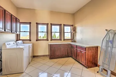 a kitchen with a washer and dryer and windows at 10 Mi to Barr Lake State Park Home with Mtn Views in Hudson