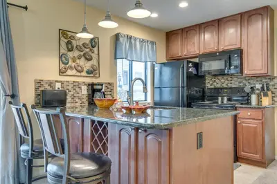a kitchen with wooden cabinets and a counter top at Englewood Apt with Patio in Denver Tech Center in Englewood