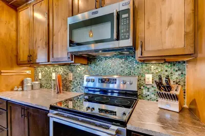 a kitchen with a stove and a microwave at Dog-Friendly Cabin in the Heart of Grand Lake! in Grand Lake