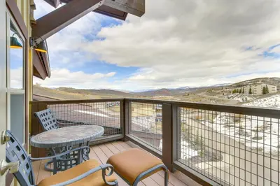 a balcony with a table and chairs and a view at Steps to Ski Lifts Base Camp One Resort Condo in Granby
