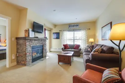 a living room with a couch and a fireplace at Steps to Ski Lifts Base Camp One Resort Condo in Granby