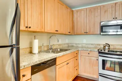 a kitchen with wooden cabinets and a sink at Steps to Ski Lifts Base Camp One Resort Condo in Granby