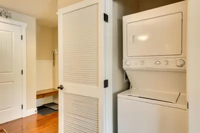 a kitchen with a washer and dryer next to a door at Steps to Ski Lifts Base Camp One Resort Condo in Granby