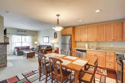 a kitchen and living room with a table and chairs at Steps to Ski Lifts Base Camp One Resort Condo in Granby