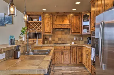 a kitchen with wooden cabinets and a stainless steel refrigerator at Colorado Escape with Mtn Views! 3 Mi to Winter Park in Fraser