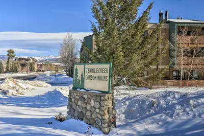 a sign in the snow in front of a building at Steps to Ski Shuttle! Frisco Condo with Indoor Pool in Frisco