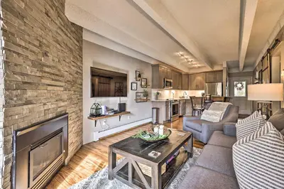 a living room with a couch and a fireplace at Steps to Ski Shuttle! Frisco Condo with Indoor Pool in Frisco
