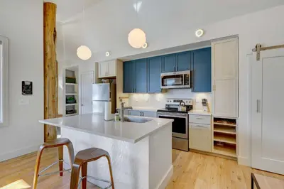 a kitchen with blue cabinets and a white counter top at Fireplace and Deck Modern Cabin in Grand Lake! in Grand Lake