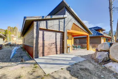 a house with a large door on the side of it at Fireplace and Deck Modern Cabin in Grand Lake! in Grand Lake