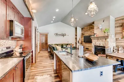 a kitchen and living room with a fireplace at 2 Blocks To Grand Lake Downtown Western Cabin! in Grand Lake