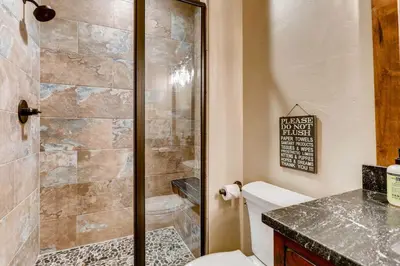 a bathroom with a shower stall and a toilet at 2 Blocks To Grand Lake Downtown Western Cabin! in Grand Lake