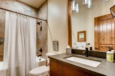 a bathroom with a sink and a toilet and a shower at 2 Blocks To Grand Lake Downtown Western Cabin! in Grand Lake