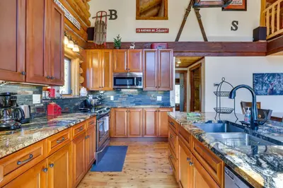 a large kitchen with wooden cabinets and a wooden floor at Access to Rocky Mtn Natl Park Grand Lake Cabin in Grand Lake