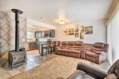 a living room with a couch and a stove at Near Lake Granby Grand Lake Townhome with Views in Grand Lake