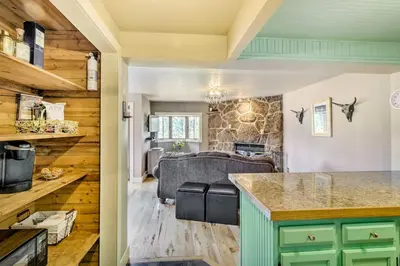 a kitchen and living room with a couch in the background at Winter Park Studio Condo - 5 Mins to Downtown! in Winter Park