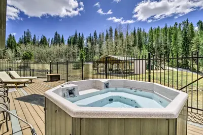 a hot tub on a deck with a fence at Winter Park Studio Condo - 5 Mins to Downtown! in Winter Park