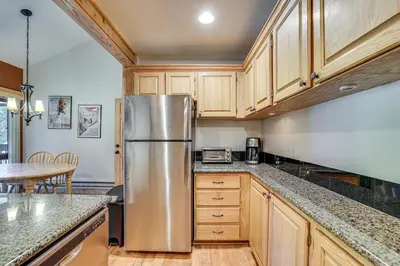 a kitchen with wooden cabinets and a stainless steel refrigerator at Ski Shuttle and Mountain Views Keystone Resort Home in Keystone