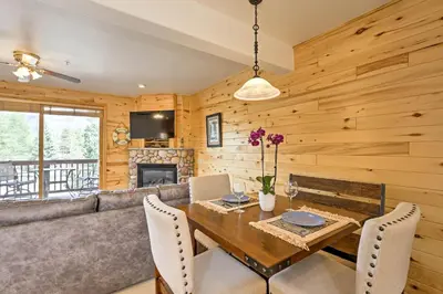 a living room with a couch and a table with chairs at 7 Mi to National Park Grand Lake Condo with Deck! in Grand Lake