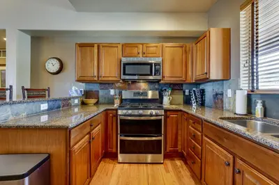 a kitchen with wooden cabinets and stainless steel appliances at 1 Mi to Granby Ranch Mtn Home with Deck in Granby
