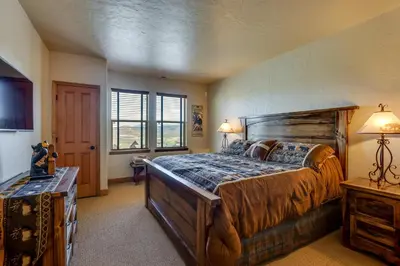 a bedroom with a large wooden bed and a window at 1 Mi to Granby Ranch Mtn Home with Deck in Granby