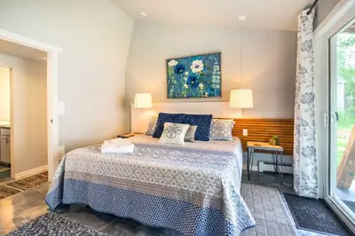 a bedroom with a bed with a blue and white bedspread at Fort Collins Vacation Rental with Private Hot Tub! in Fort Collins