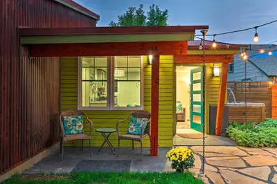 a yellow house with two chairs and a patio at Fort Collins Vacation Rental with Private Hot Tub! in Fort Collins