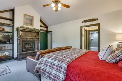 a bedroom with a red bed and a fireplace at 11 Mi to Slopes Frisco Home with Hot Tub and Sauna! in Frisco