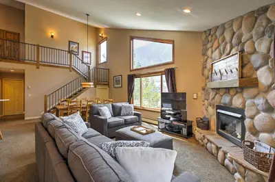 a living room with a large stone wall at Half-Mi to Copper Mtn Slopes Frisco Unit with Loft in Frisco