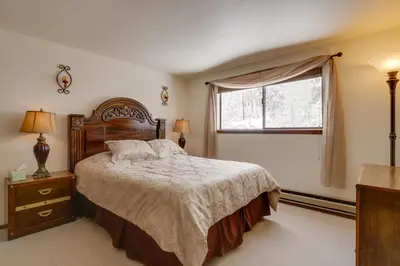 a bedroom with a large bed and a window at Winter Park Condo with Hot Tubs, 4 Mi to Ski Resort! in Winter Park