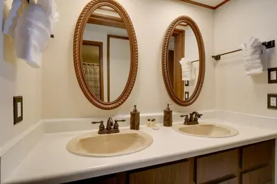 a bathroom with two sinks and two mirrors at Winter Park Condo with Hot Tubs, 4 Mi to Ski Resort! in Winter Park