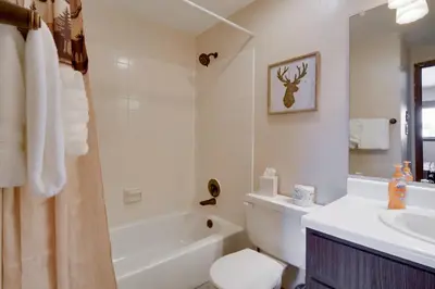 a bathroom with a tub and a sink and a toilet at Winter Park Condo with Hot Tubs, 4 Mi to Ski Resort! in Winter Park