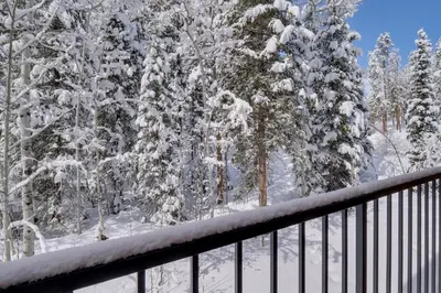 a view from a balcony of snow covered trees at Winter Park Condo with Hot Tubs, 4 Mi to Ski Resort! in Winter Park